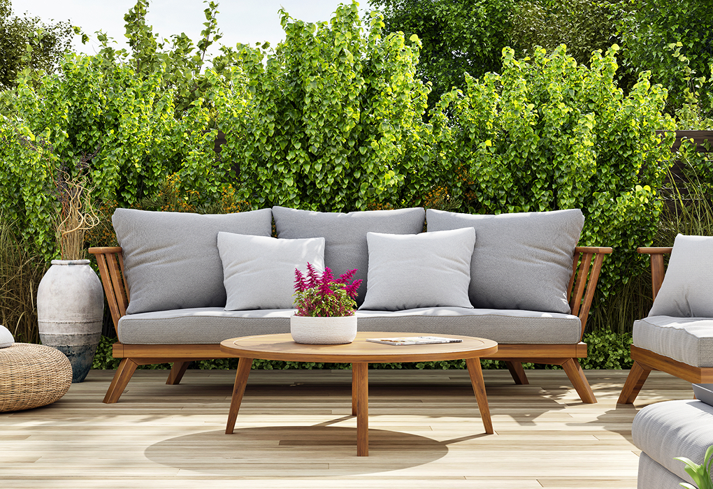 backyard patio with furniture on it and green bushes in the background