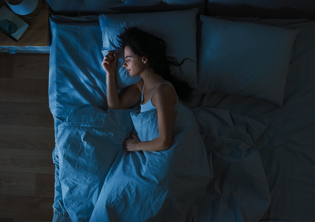sleep for stress management, someone alseep in dark room in bed