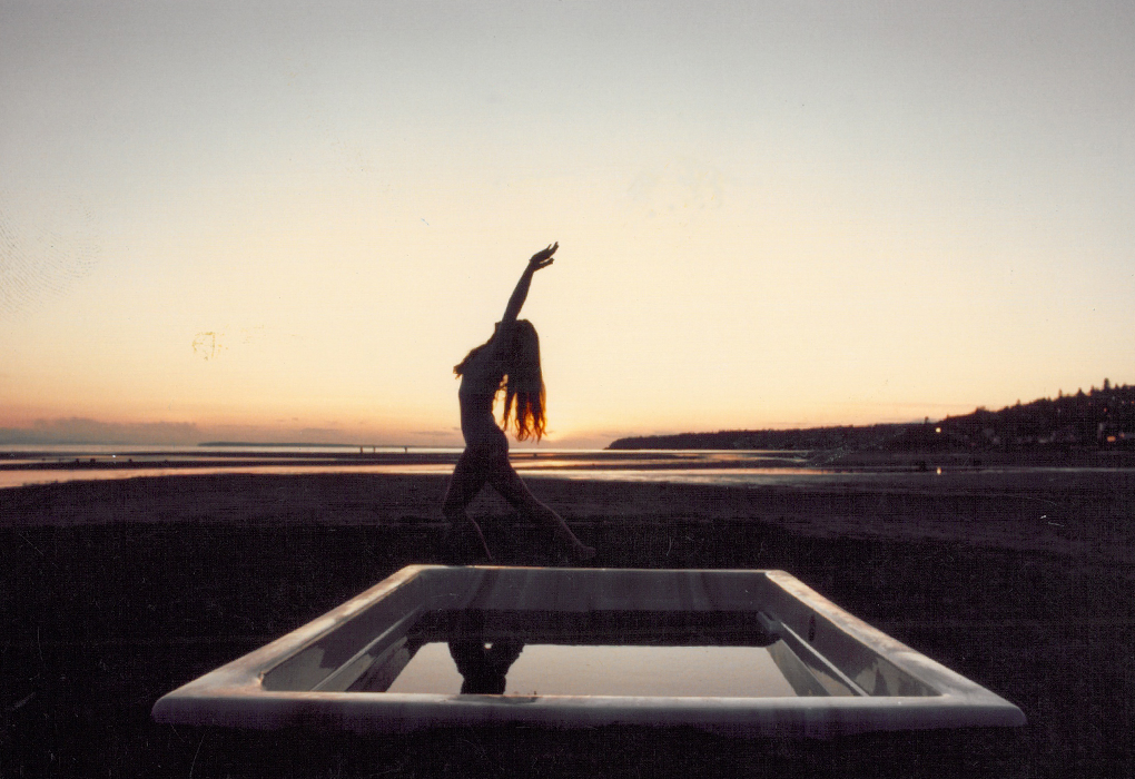 sunset picture with beachcomber hot tub on beach and woman doing yoga pose