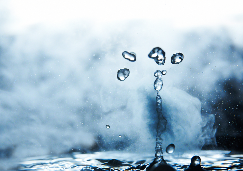 water drop falling into a vast expanse of water