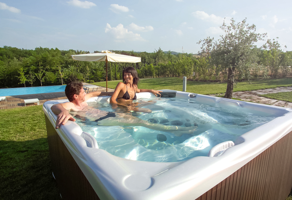 a man and a woman sitting in a beachcomber hot tub smiling at each other