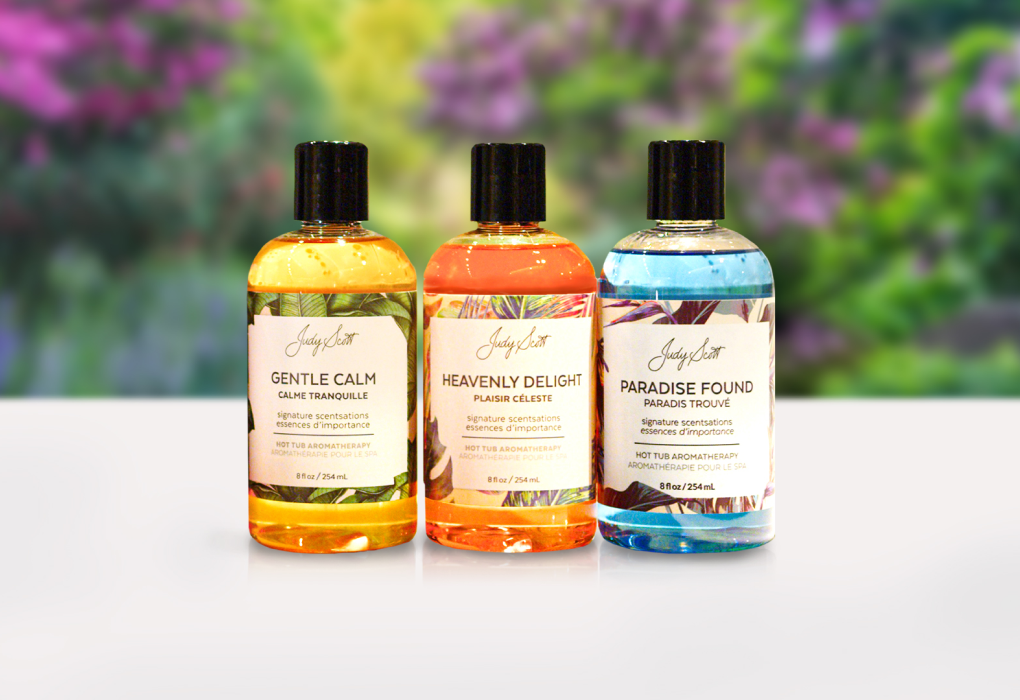three beachcomber signature scentsations bottles on a white table with blurred flower background